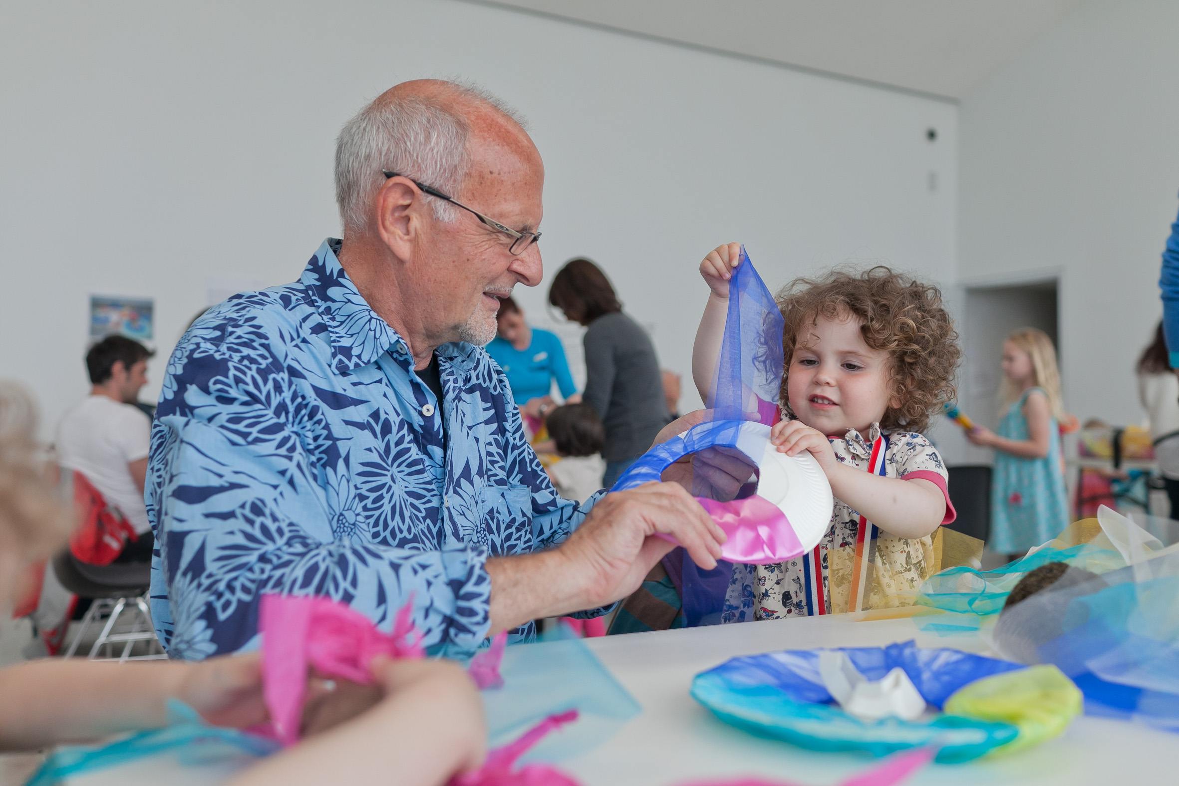 Man helping a child with a colourful art project at Turner Contemporary