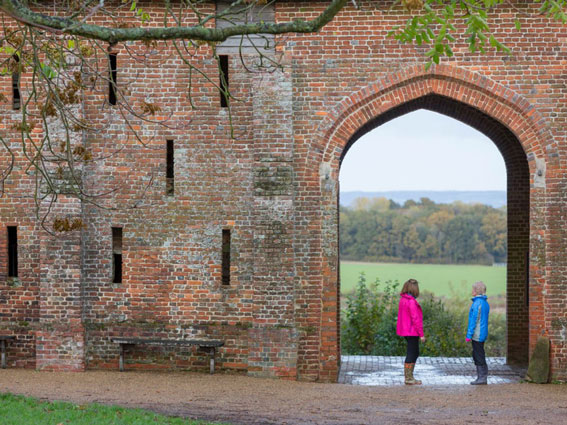 Two people under an archway in Sissinghurst Castle grounds