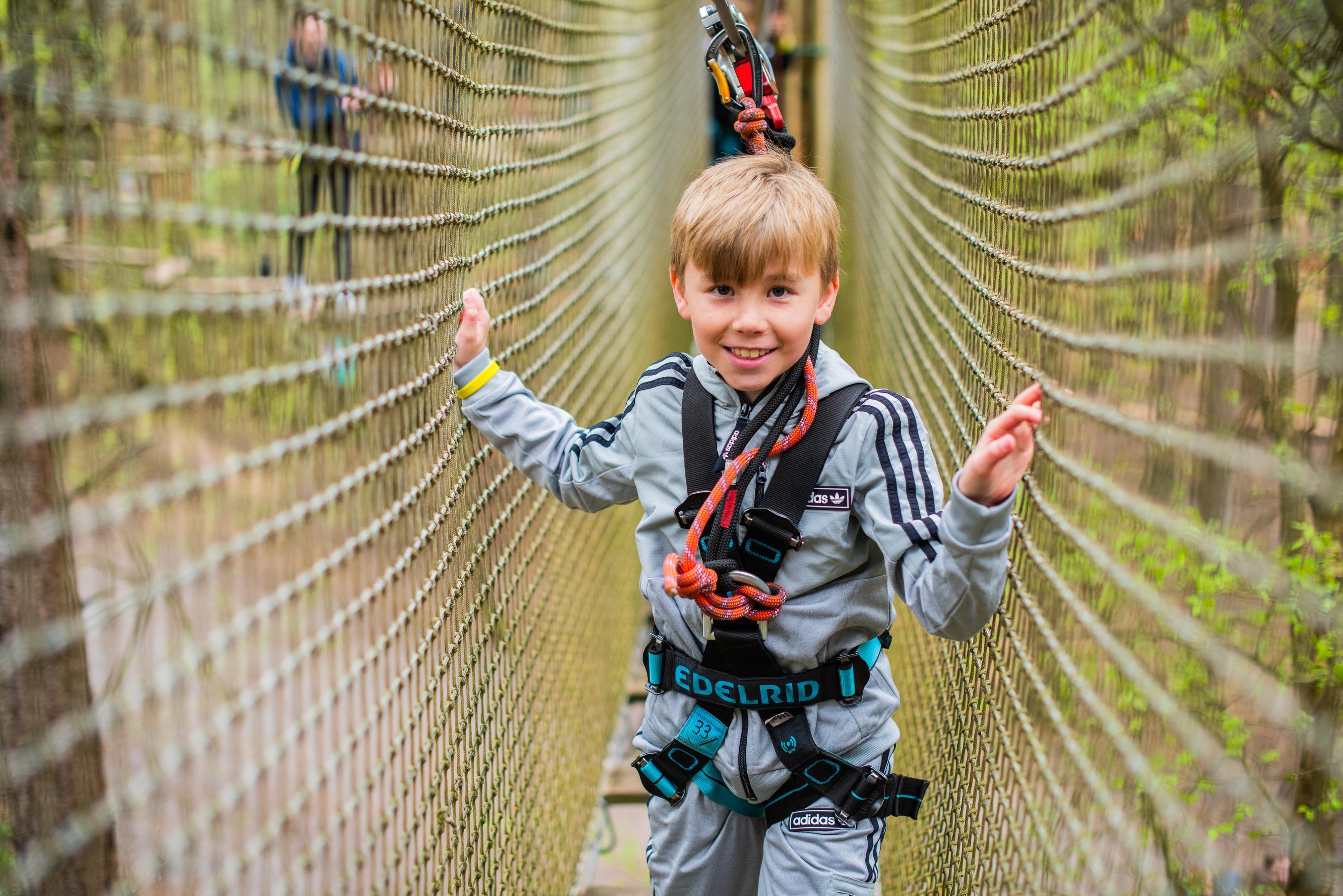 Young boy in net on Go Ape course