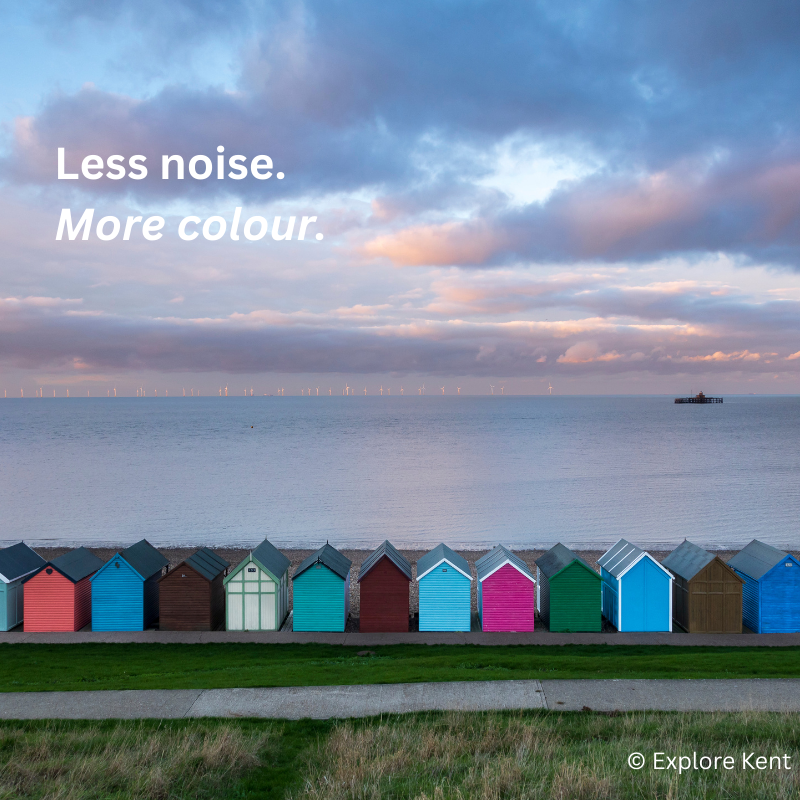 View of colourful beach huts and sunset over Herne Bay