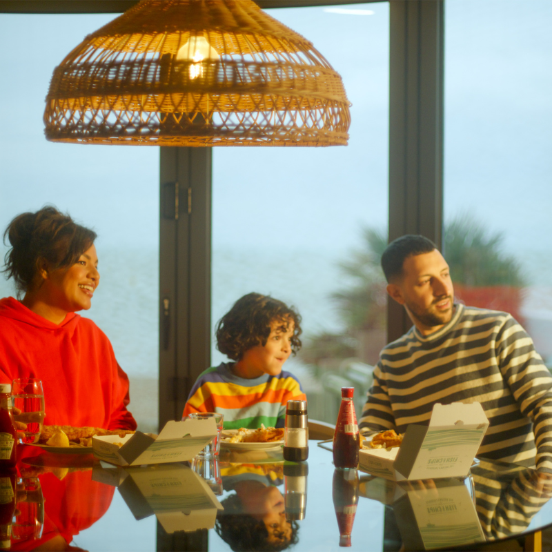 family around the dining table eating fish and chips