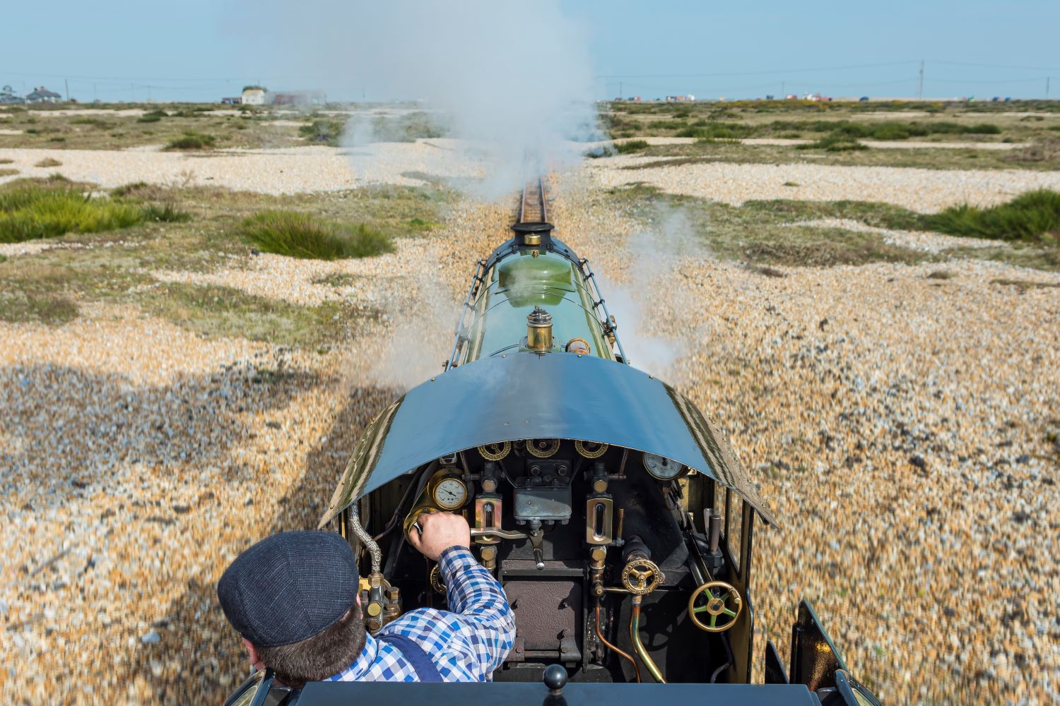Driver driving Romney, Hythe and Dymchurch Railway steam train through Romney Marsh