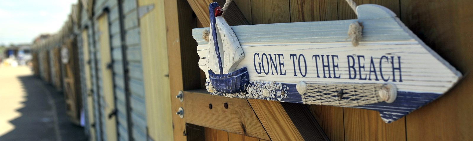 Row of beach huts with 'gone to beach' sign - credit Thanet Tourism.JPG