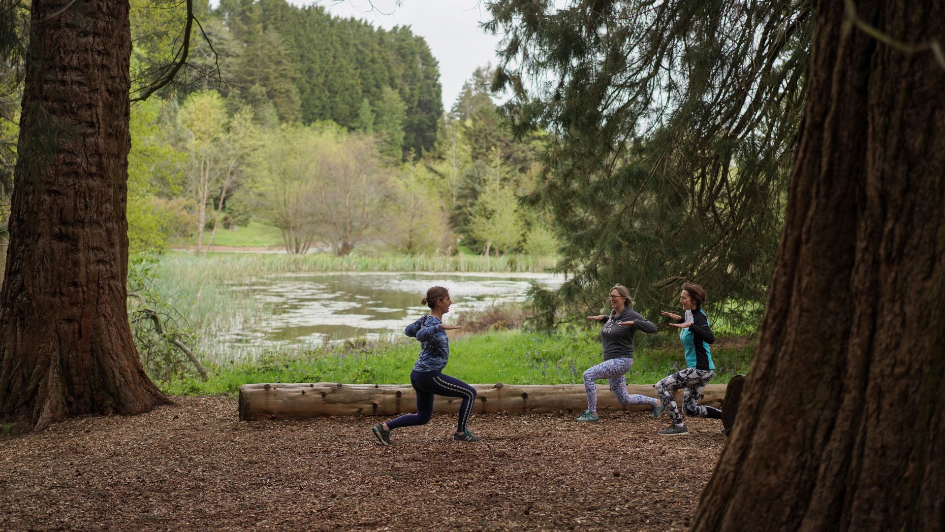 Three women doing yoga in Bedgebury National Pinetum and Forest
